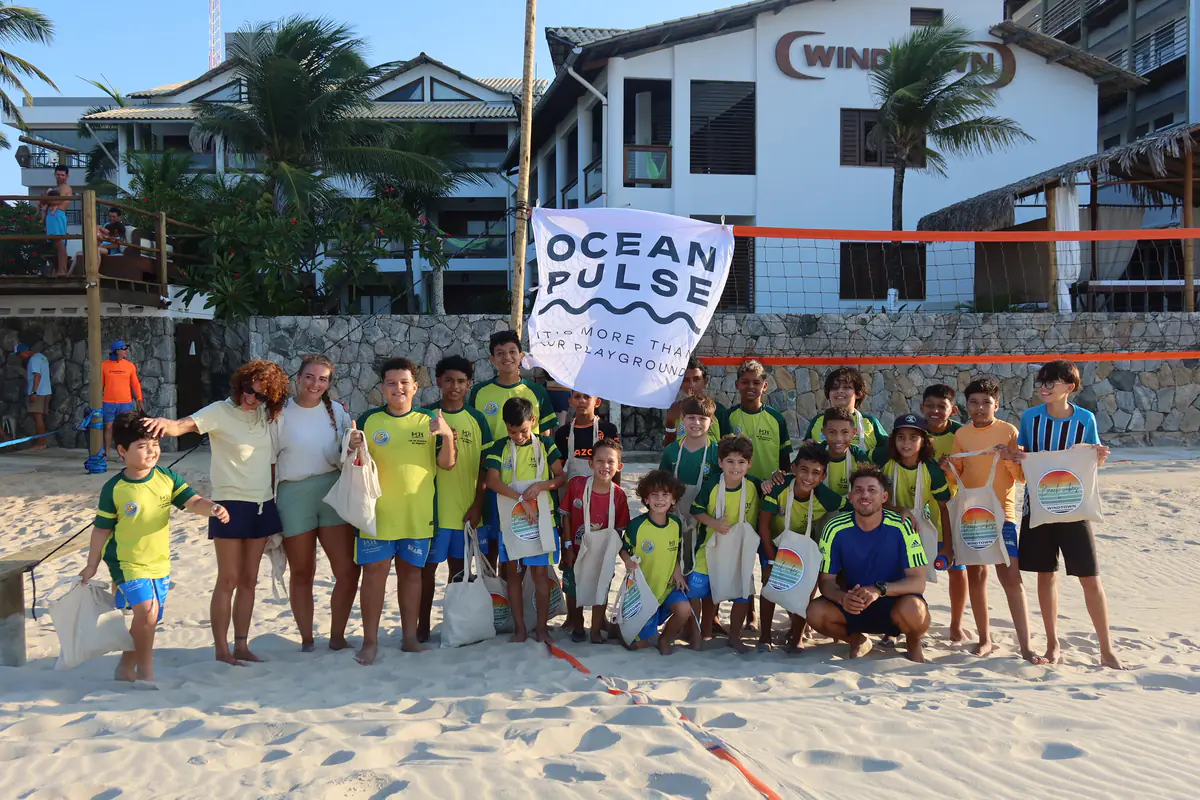 Children and adults with an OceanPulse flag on the beach