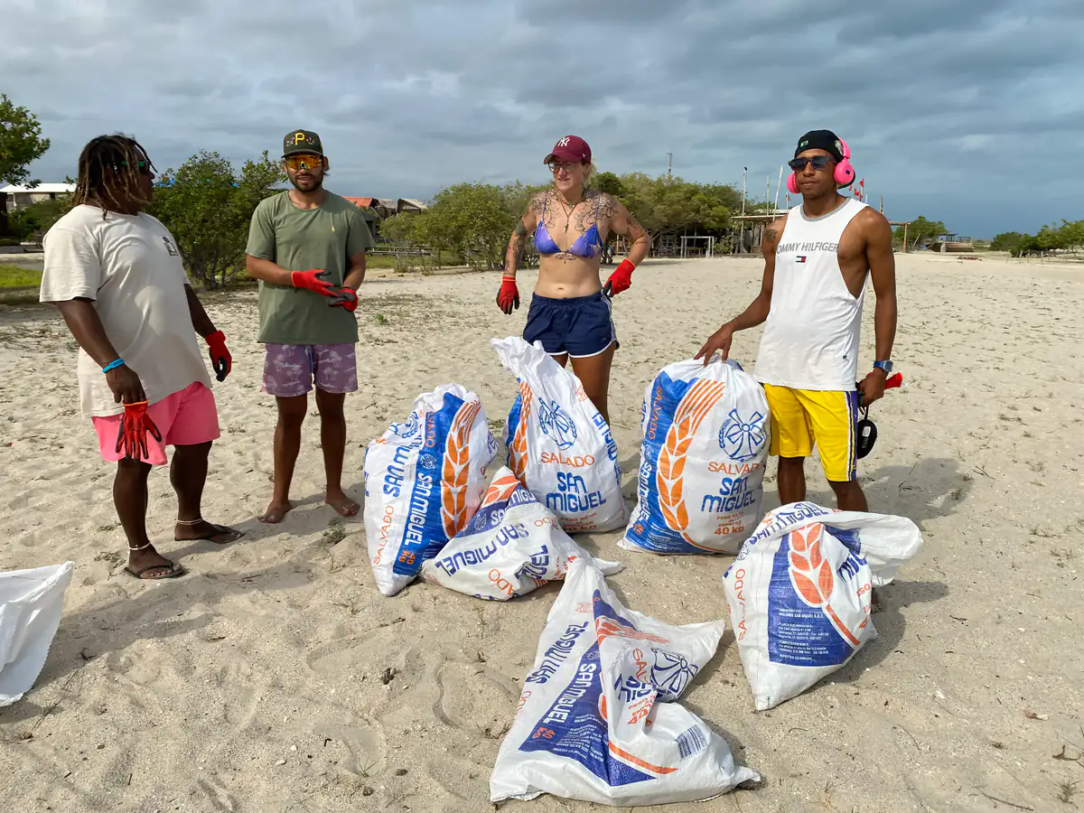 Volunteers with filled waste bags on the beach